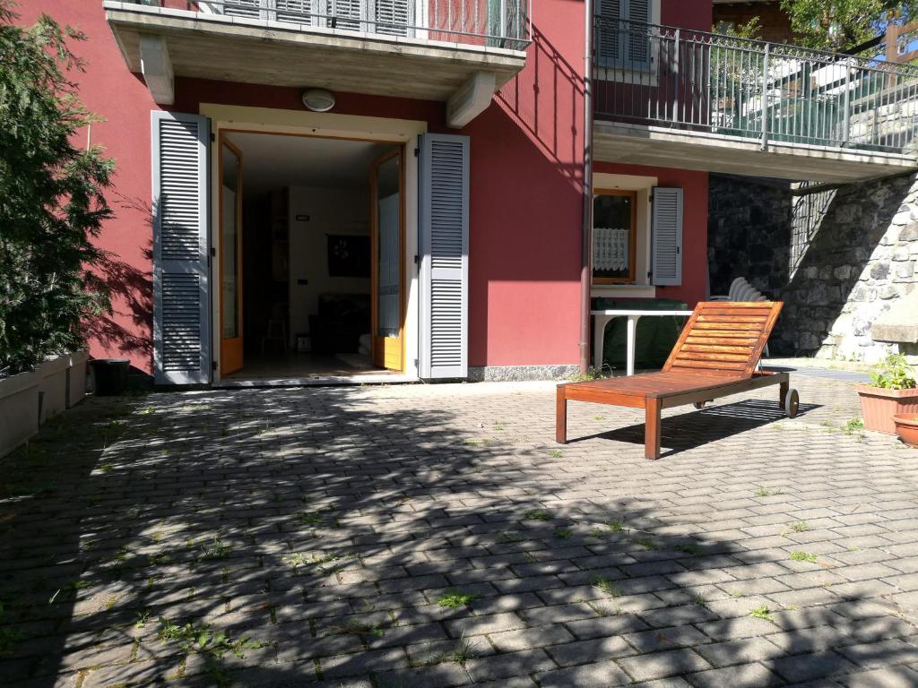 a bench sitting in front of a pink building at Appartamento Fiordalpe in Valdidentro