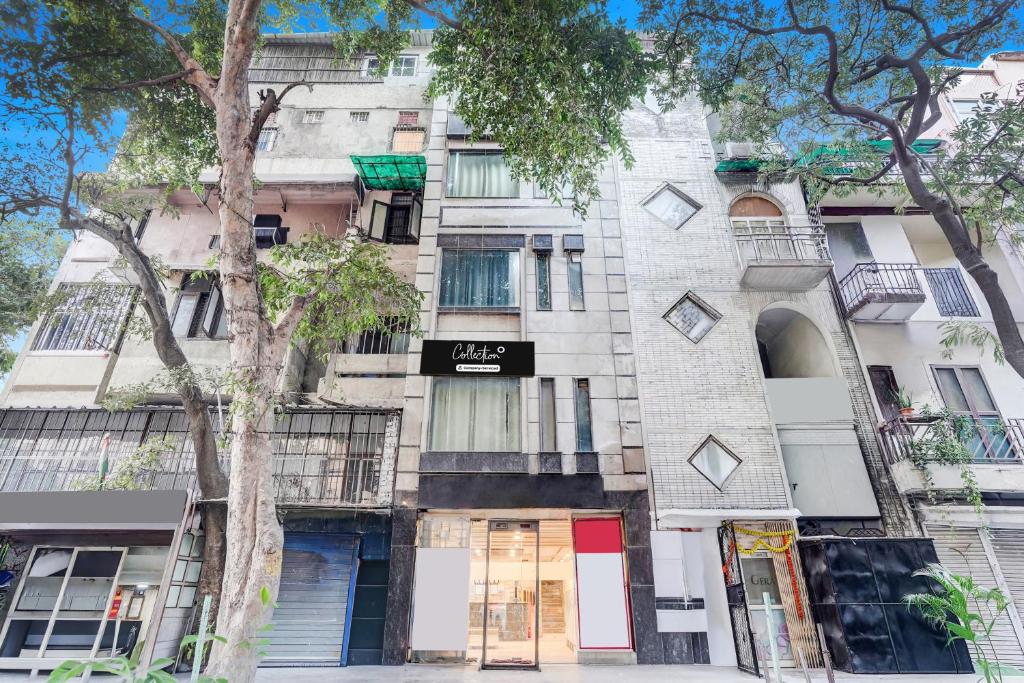 Collection O Kalka Ji Formerly Hotel Gera في نيودلهي: مبنى شقق على شارع فيه اشجار