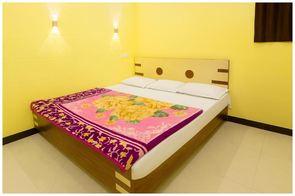 a bedroom with a bed with a colorful blanket on it at Hotel Premium IN Tulsi GH Near Shri Mahakaleshwar Jyotirlinga Temple - Fully Air Air Conditioning Rooms - Prime Location in Ujjain