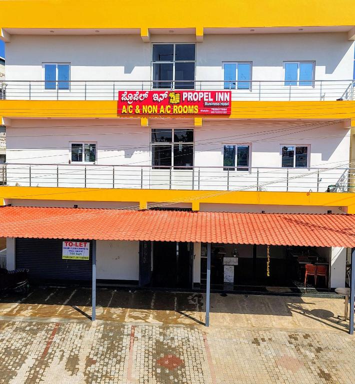 a building with a red and yellow sign on it at Hotel Propel Inn in Dobbspet