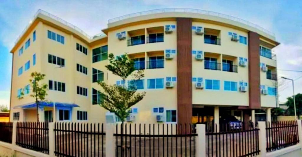 een gebouw met blauwe ramen voor een hek bij SDDP Apartment in San Kamphaeng