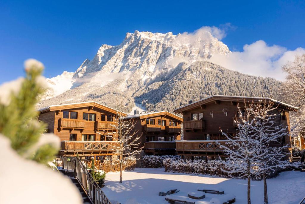 a resort with a snow covered mountain in the background at Bergresort Zugspitze Ehrwald by ALPS RESORTS in Ehrwald