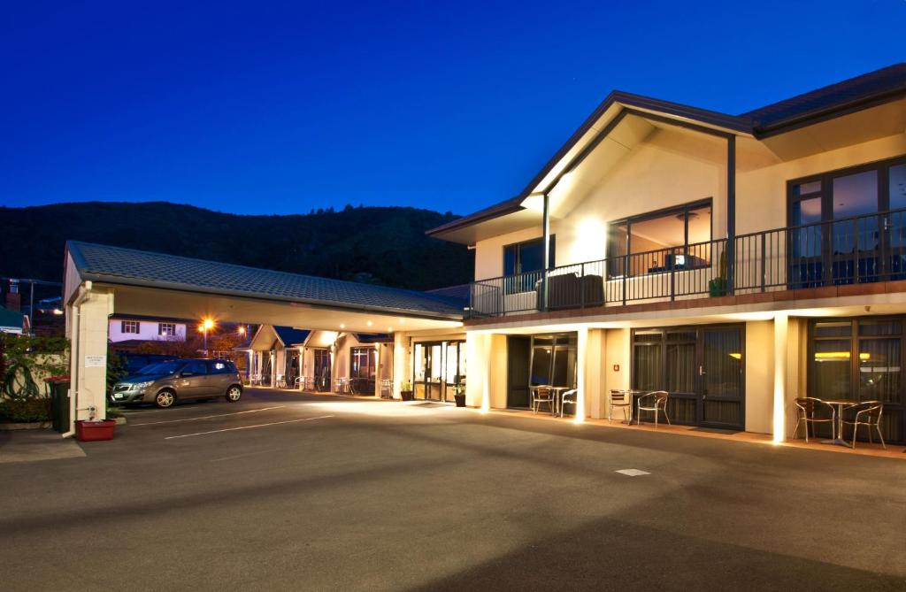 a row of buildings with a car parked in a parking lot at Broadway Motel in Picton