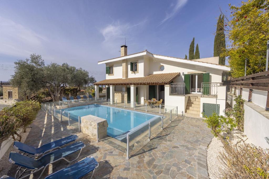 a house with a swimming pool in front of a house at Rhodia Villa in Ayios Isidhoros