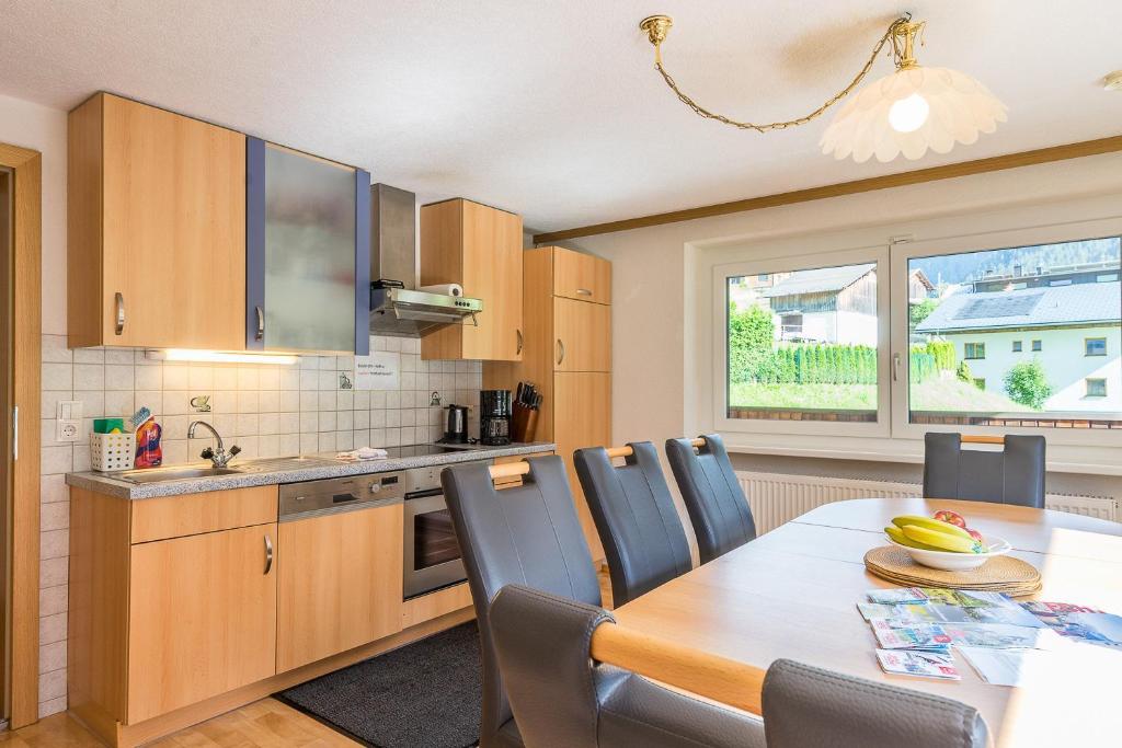 a kitchen with a wooden table and a dining room at Haus Tramontana in Gaschurn