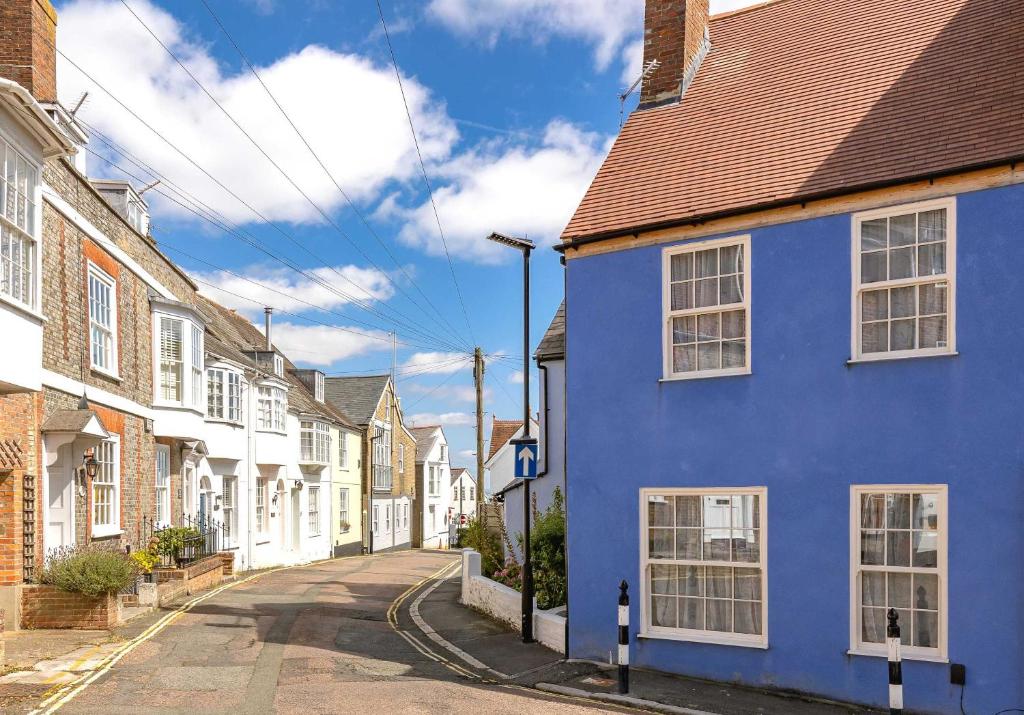 a blue house on a street with white houses at Charming Jersey Cottage with parking 8 Guests in Cowes