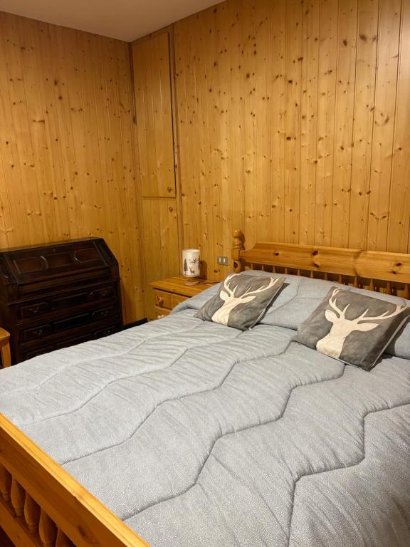 een groot bed in een kamer met houten wanden bij Altea Retreat in Ponte di Legno