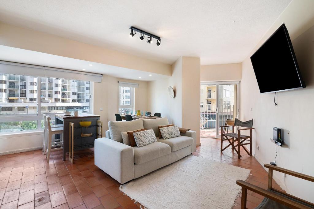 a living room with a couch and a tv at Apartamento Davasa in Armação de Pêra