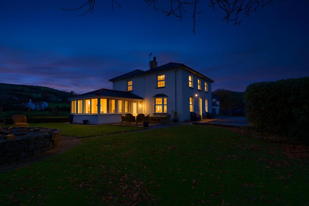 a house with its lights on at night at YR HEN FICERDY in Aberystwyth