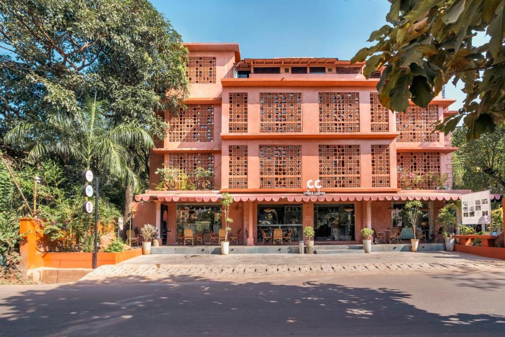 a large pink building with a street in front of it at Unseen Boutique Hotel, Assagao in Assagao