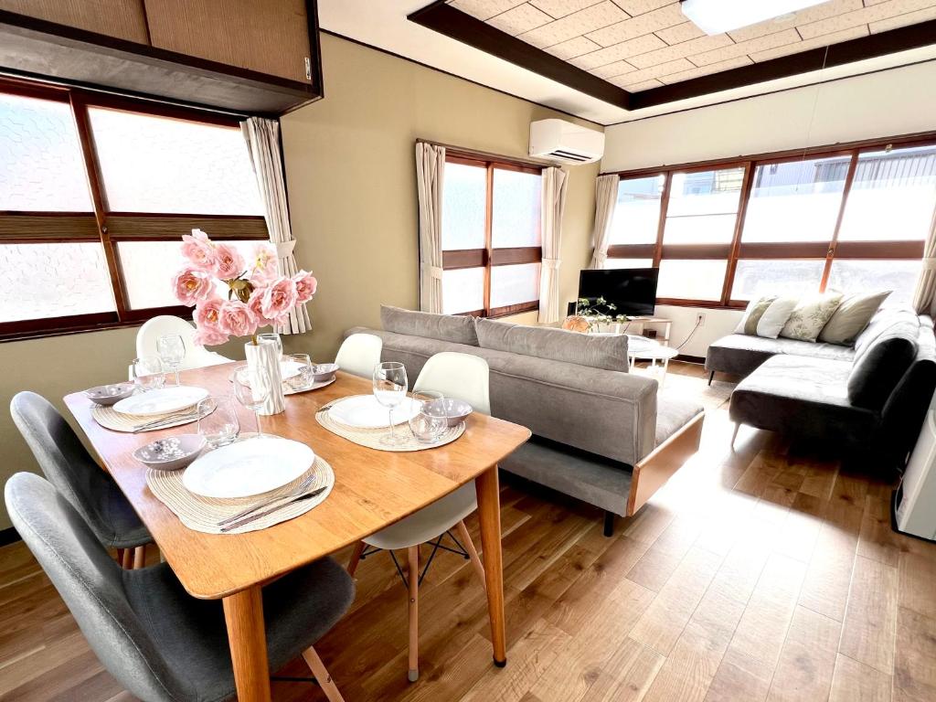 a living room with a table and a couch at 2025年12月OPEN! 豊橋民泊 最大13名様 駐車場2台無料 駅徒歩7分 Traditional Japanese house ,Toyohashi Aichi in Toyohashi