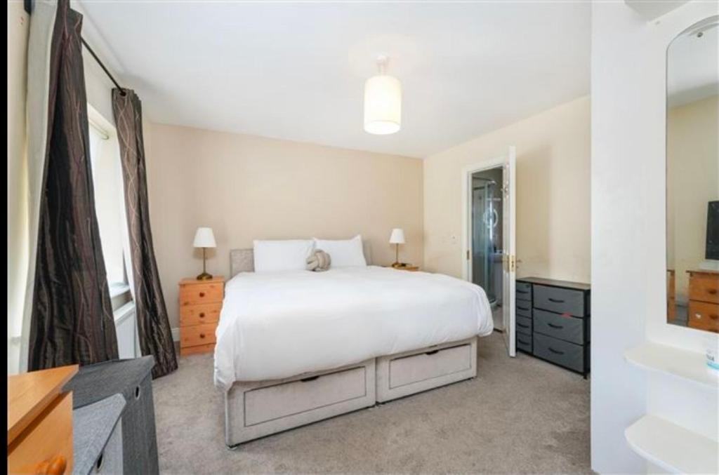 3 Cosy Bedrooms in a House 6 people في تيريلسْتاون: غرفة نوم بها سرير ومغسلة وحوض استحمام