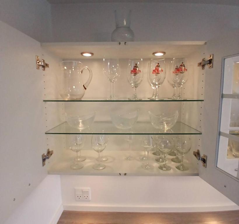 a bunch of wine glasses on shelves in a wall at Eksklusiv stort boende i Fredrikshavn in Frederikshavn