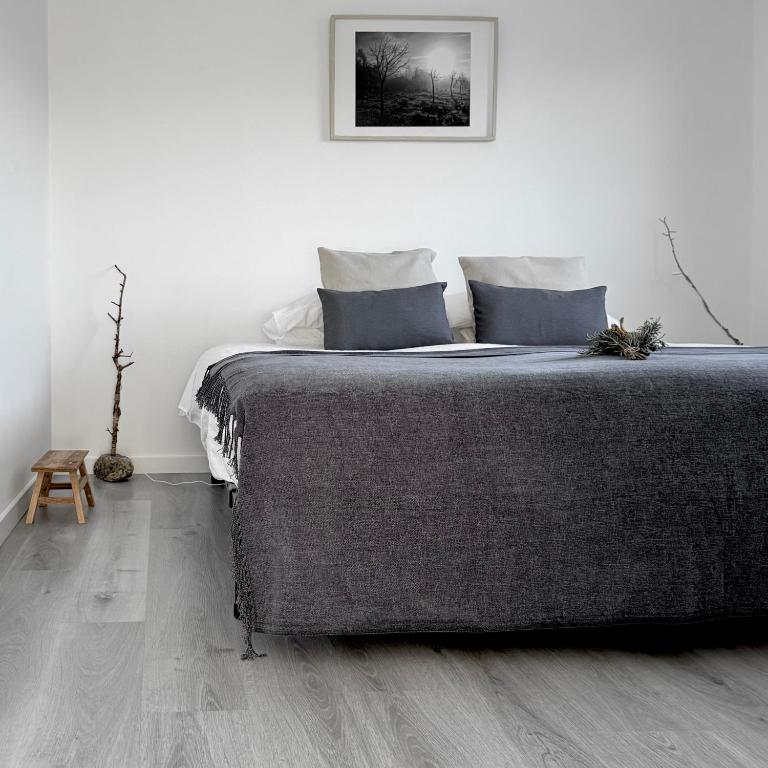 a bedroom with a large bed and a wooden floor at M Butterfly in Alvorge