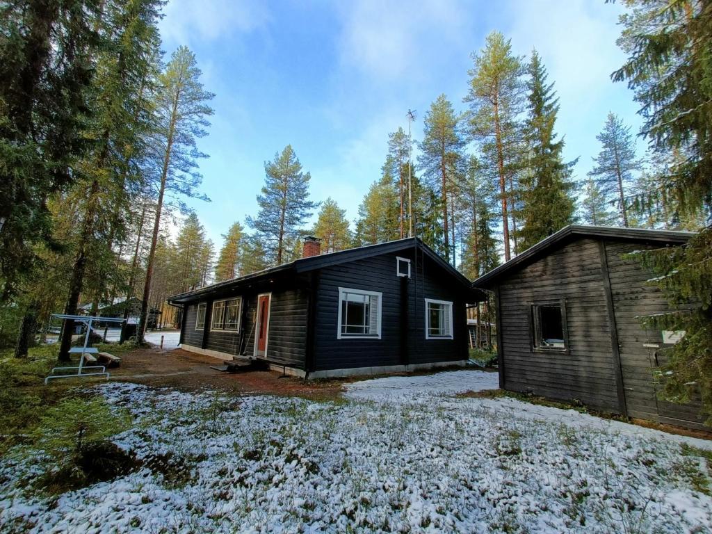 een hut in het bos met sneeuw op de grond bij Syötemaja in Pudasjärvi