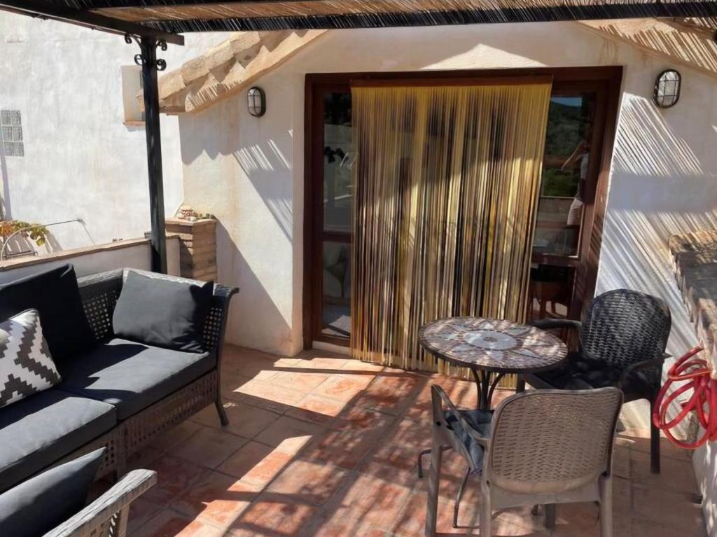 a patio with a couch and a table and chairs at Casa Balcón in Granada