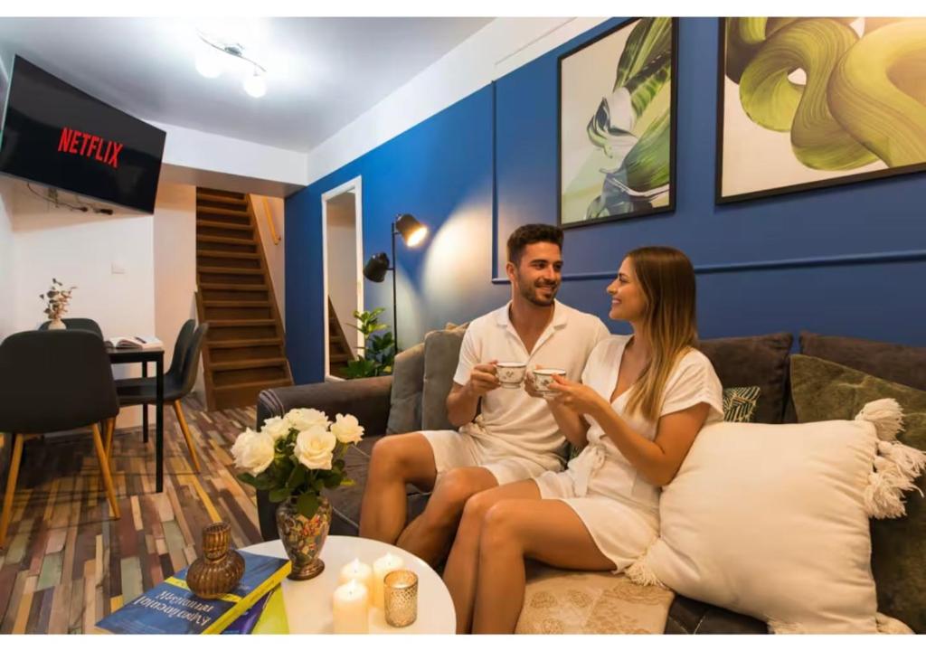a man and a woman sitting on a couch at Central 2-Bedroom House with Shared Courtyard in Bucharest