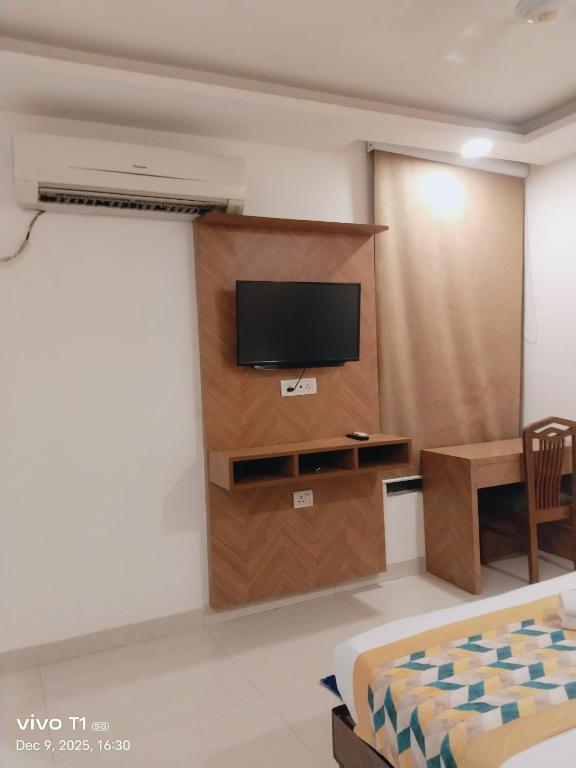a room with a tv and a table and a bed at Tejas stay in New Delhi