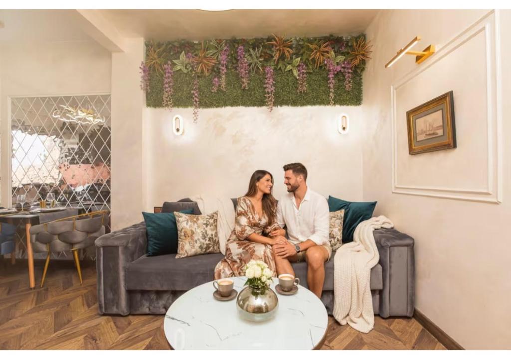 a bride and groom sitting on a couch in a living room at Royalty Apartment with City Views on Calea Victoriei in Bucharest
