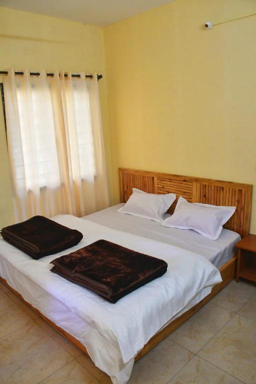 a bedroom with two beds with towels on them at Ivan homestay in Kulu
