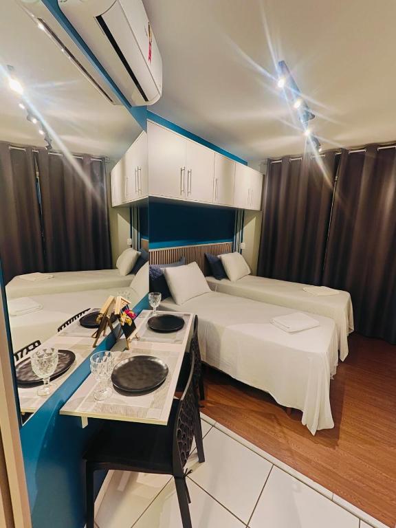 a hotel room with two beds and a table at Flat Expo Anhembi WiseSP Accommodations in São Paulo