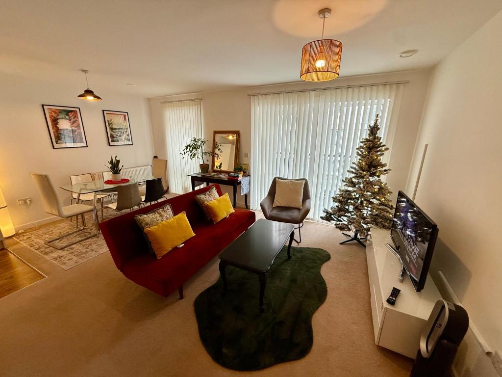 a living room with a christmas tree and a red couch at Issara Apartments 49 - Great location & Private Parking in Portsmouth