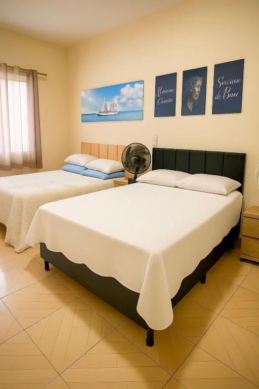 Dos camas una al lado de la otra en una habitación. en apartamento Completo Localização Excelente Centro, en Canindé