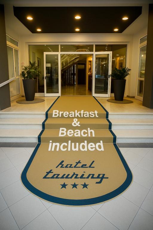 a welcome mat on the front of a building at Hotel Touring in Lido di Jesolo