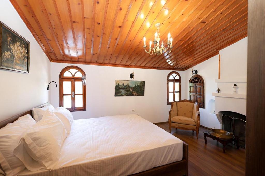 a bedroom with a large white bed and a chandelier at Villa Starova in Berat