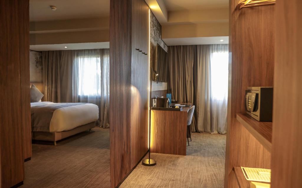 a hotel room with a bed and a television at Villa Blanca Urban Hotel in Casablanca