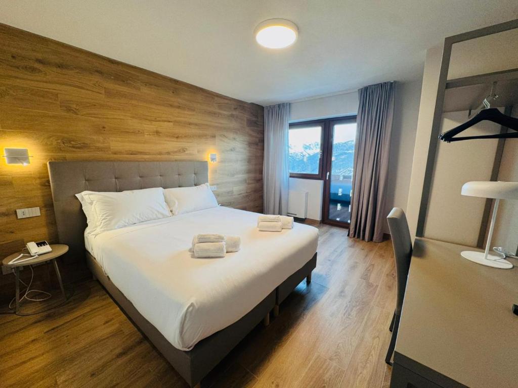 a bedroom with a large bed with a wooden wall at Lift Hotel in Sauze d'Oulx