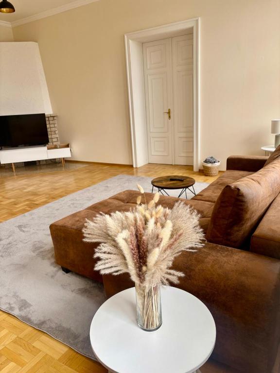 a living room with a couch and a vase of flowers at Markt Eins Salonwohnung in Schöppenstedt