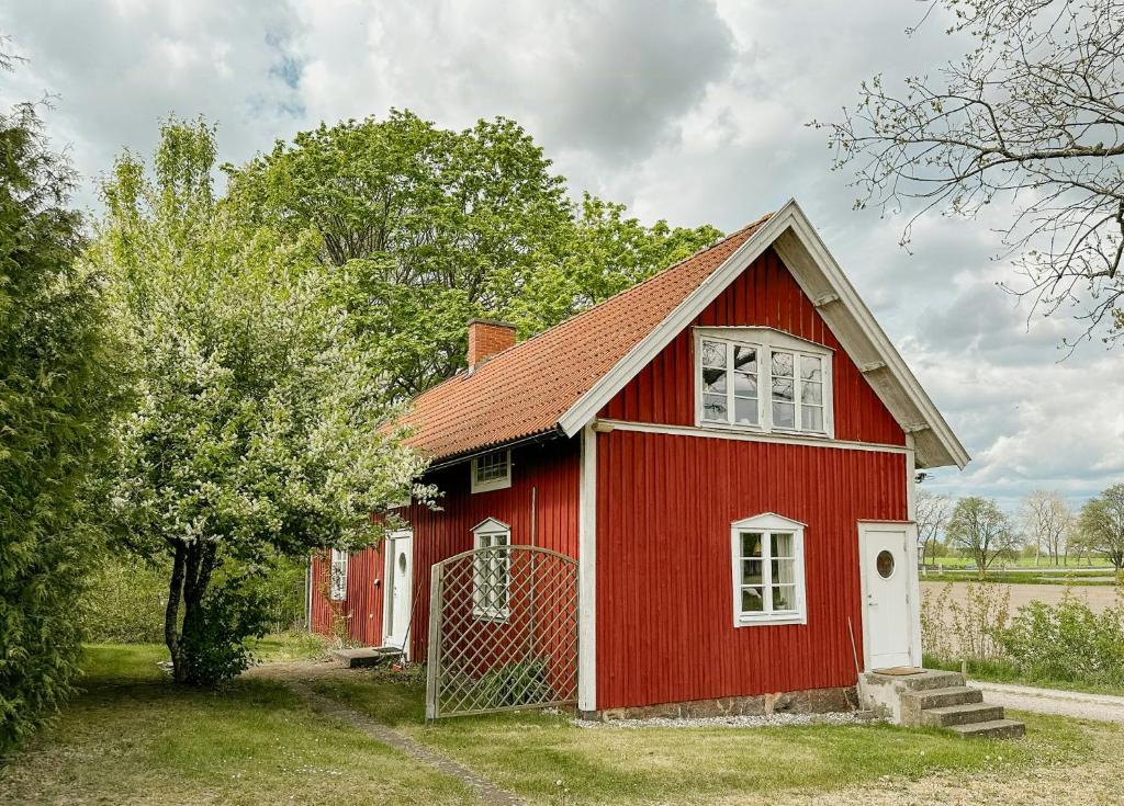 a red house with a fence in front of it at Traditional Red House By The Lake In Småland in Åby