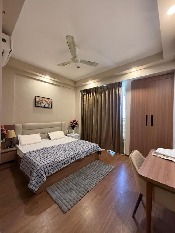 Schlafzimmer mit einem Bett, einem Tisch und einer Decke in der Unterkunft Luxury stays in Greater Noida