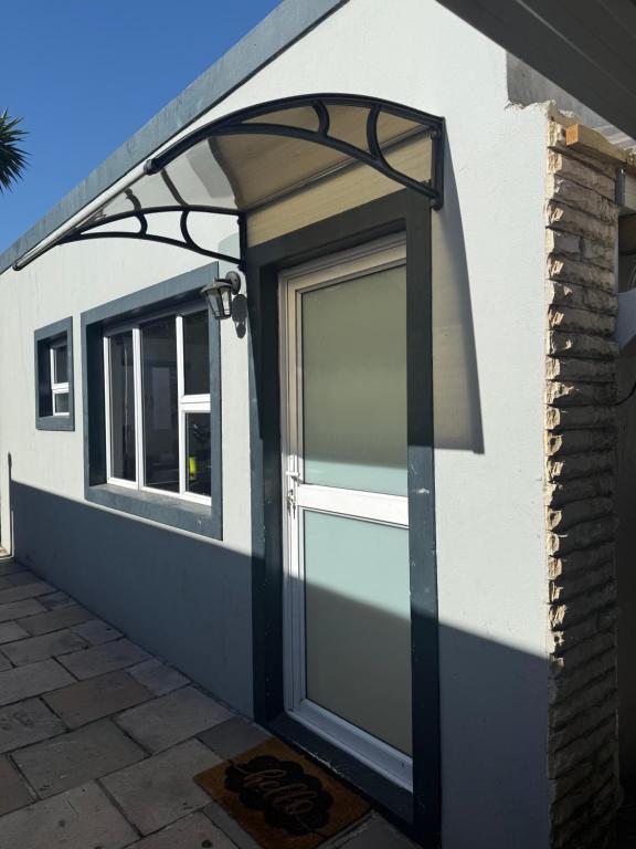 Sunny Snooze Holiday Home في جودوود: باب مرآب مع مظلة على جانب المنزل