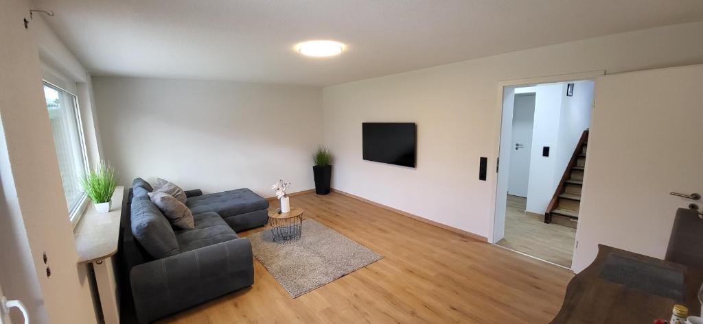 een woonkamer met een bank en een televisie bij Wunderschönes Haus mit 3 Schlafzimmern in Crailsheim