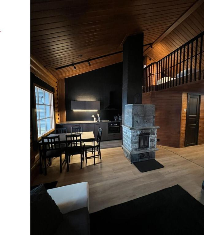 a living room with a table and a fireplace at Arvoneliöt Lomahimos 18 in Jämsä