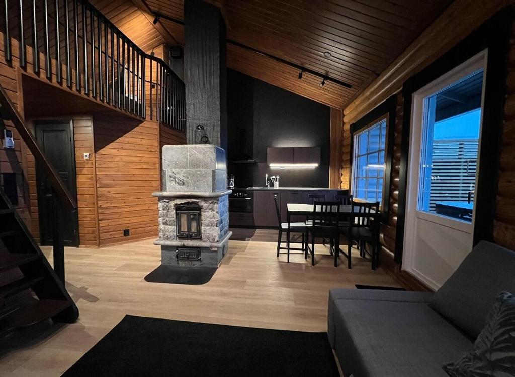 a living room with a fireplace and a dining room at Arvoneliöt Lomahimos 17 in Jämsä