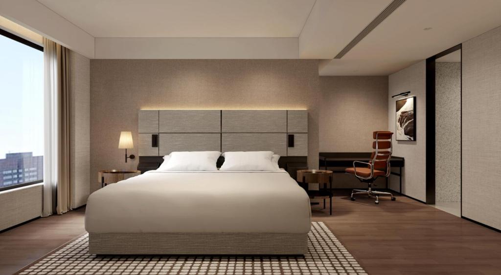 a bedroom with a large white bed and a desk at Intercity Hotel & Serviced Apartment Phnom Penh Downtown in Phumĭ Prêk Chrey