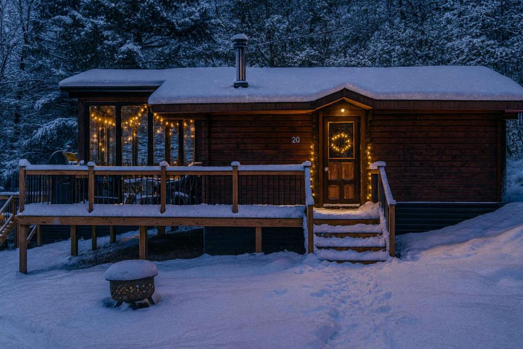 a log cabin with a porch in the snow at Lake Muskoka 3-bedroom Cottage - Pier 100 #20 in Port Carling