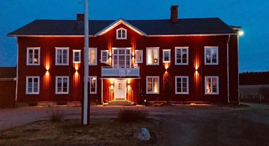 een groot rood huis met kerstverlichting bij Helsingebockens Fastigheter 
