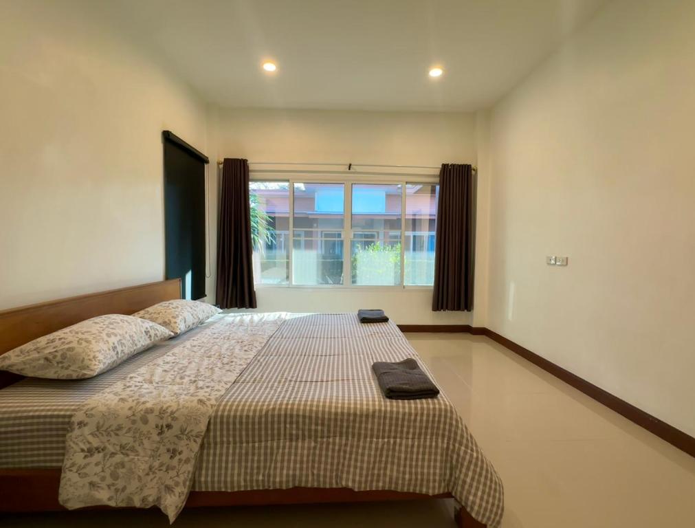 ein Schlafzimmer mit einem großen Bett mit Fenster in der Unterkunft Sea sand Bungalow in Phuket