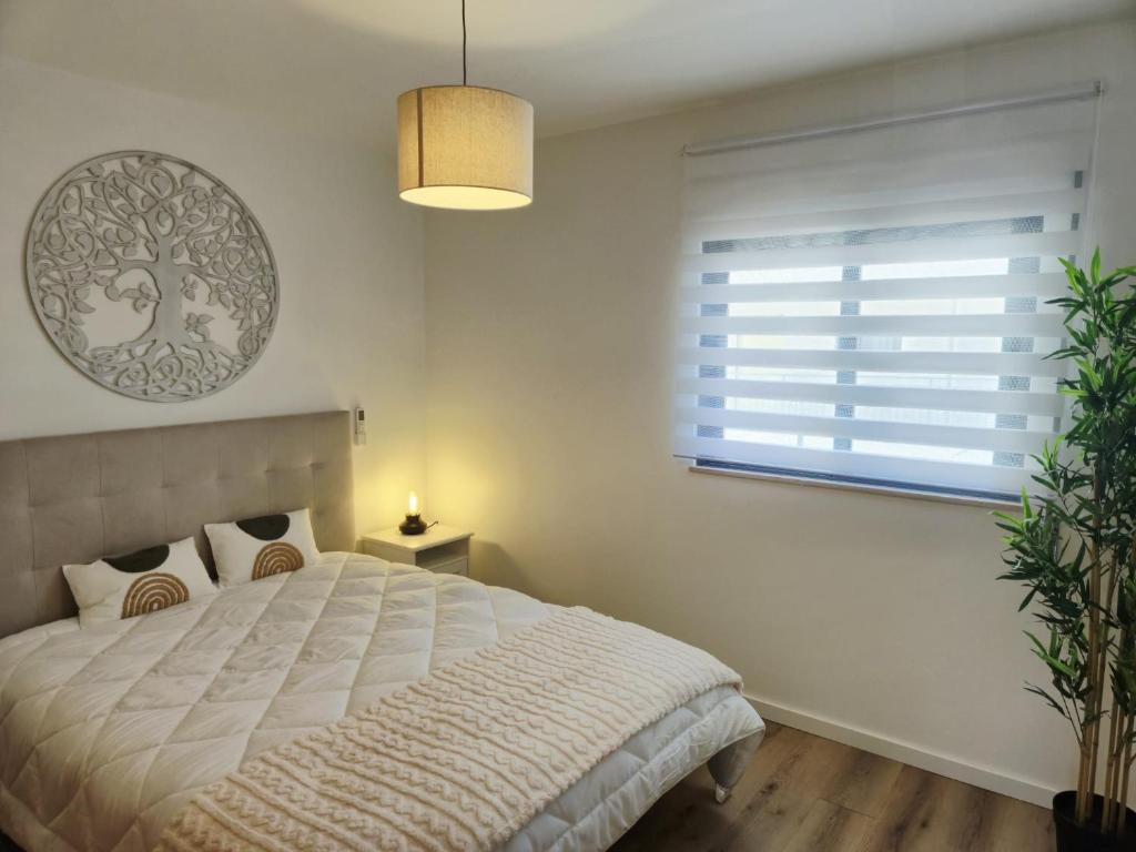 ein Schlafzimmer mit einem großen Bett und einem Fenster in der Unterkunft Downtown apartment - Terrace, garage and pool in Olhão