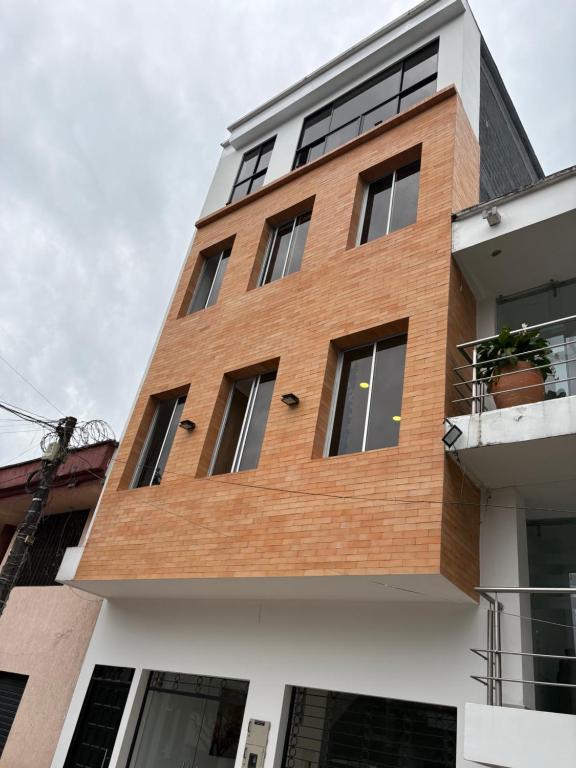 a brown brick building with a white at Hotel El Cedro Exclusive in Florencia