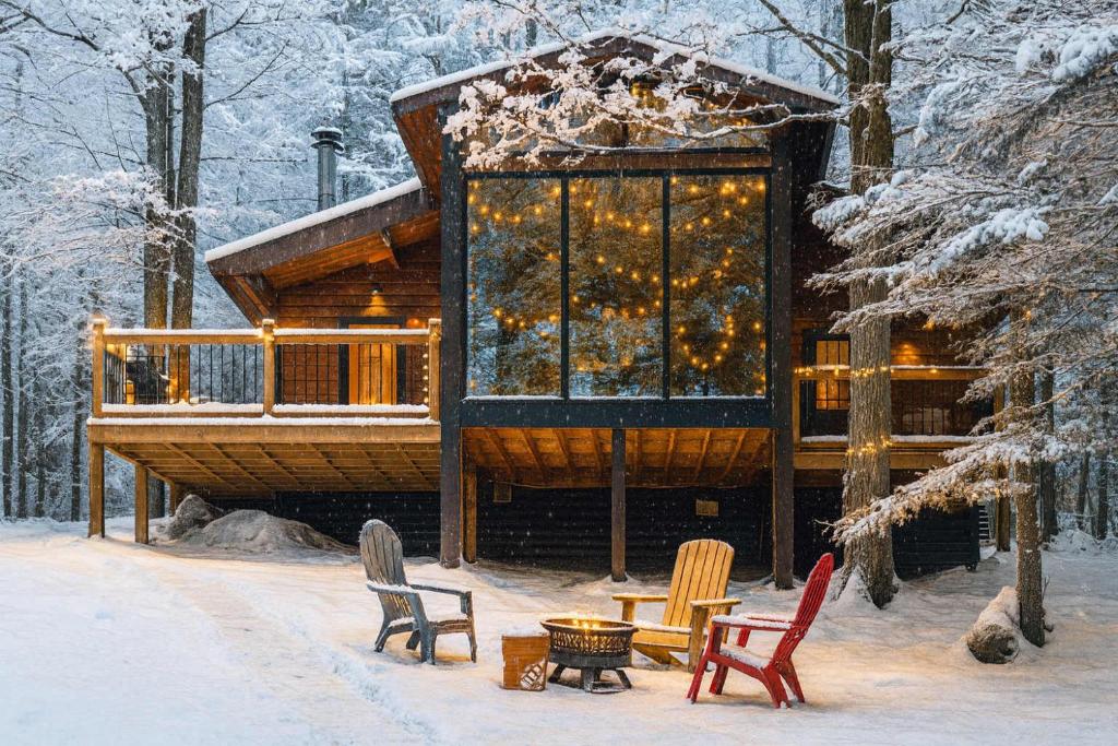 a log cabin in the snow with chairs and lights at Lake Muskoka 3-bdrm Cottage - Pier 100 #70 in Port Carling