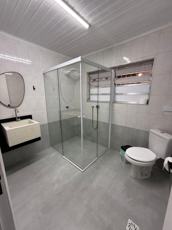 a bathroom with a shower and a toilet and a sink at Casa Quintal de Bertioga Centro in Bertioga