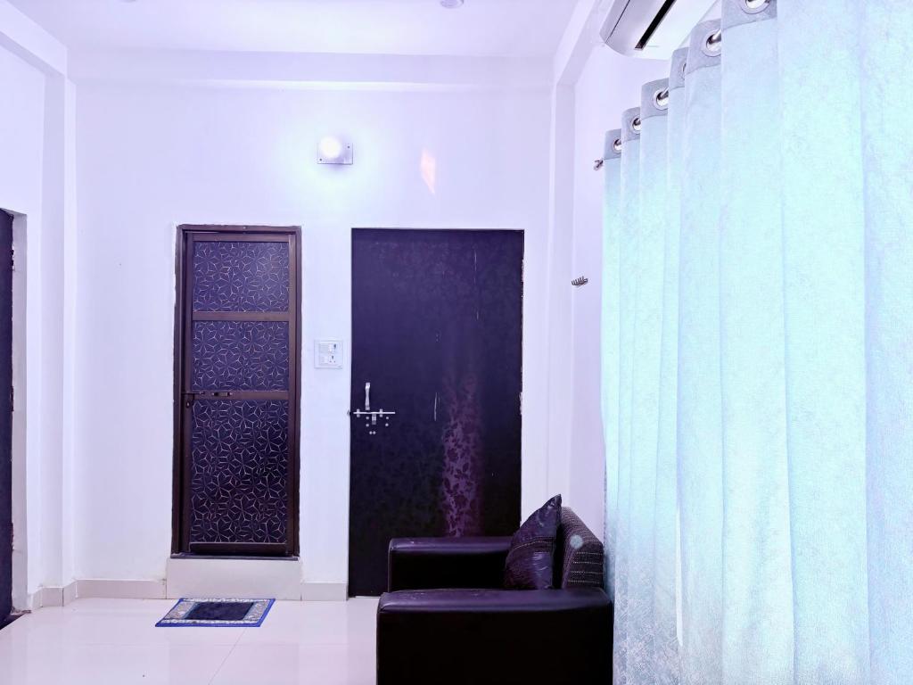 una habitación con 2 sillas y una puerta con cortinas en Majestic Inn Home Stay, en Varanasi