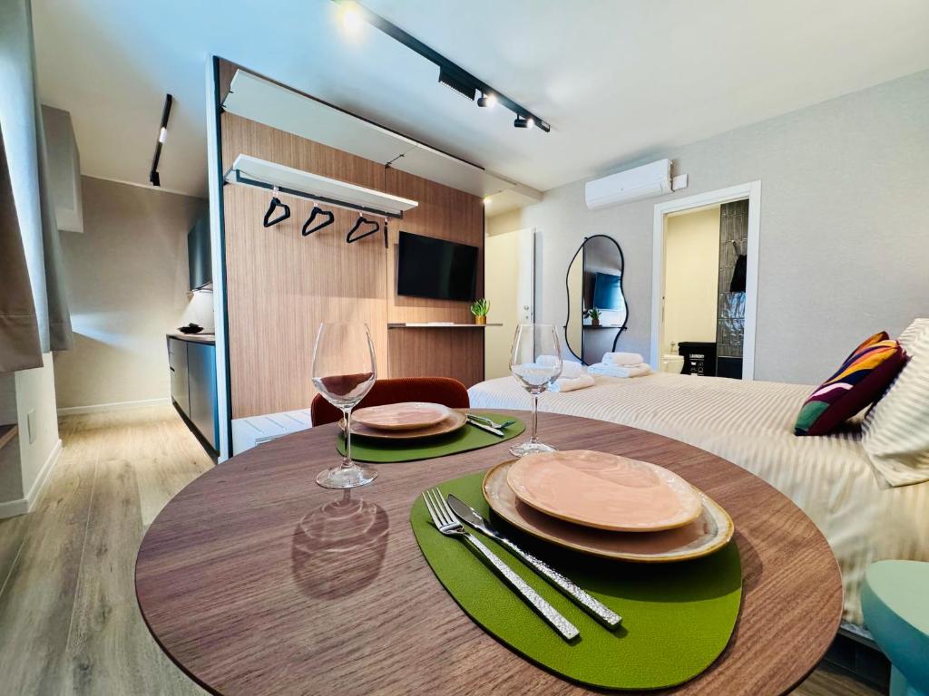 a room with a table with two glasses and a bed at Vimini Corso Cavour - City Center in Bari