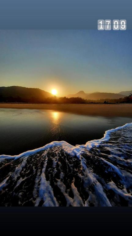un tramonto su un corpo d'acqua con la neve di Suíte Capiá a Ubatuba