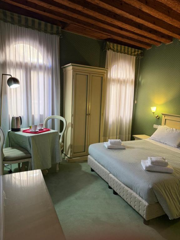 a bedroom with two beds and a table and a table and chairs at Locanda Ruga Rialto in Venice